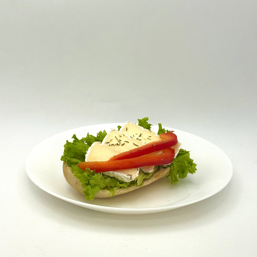 halbes belegtes Weizenbrötchen mit Camembert