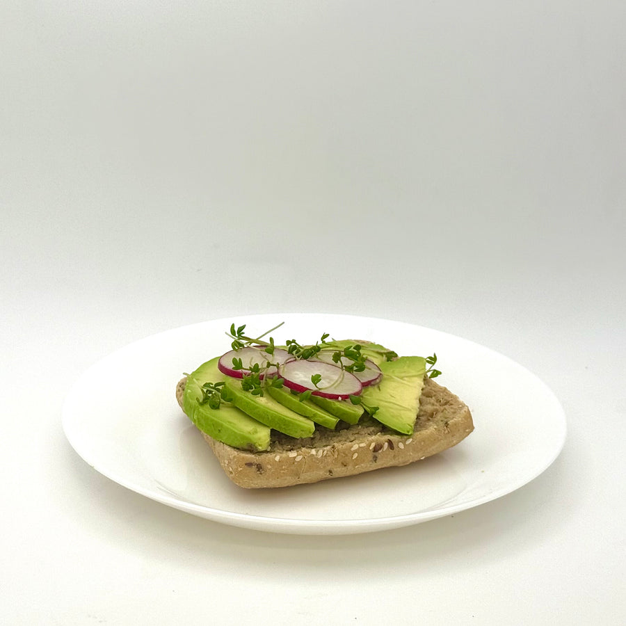 halbes belegtes Mehrkornbrötchen mit Avocado vegan