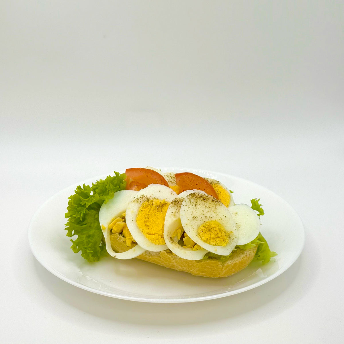 half a filled wheat roll with a boiled egg 