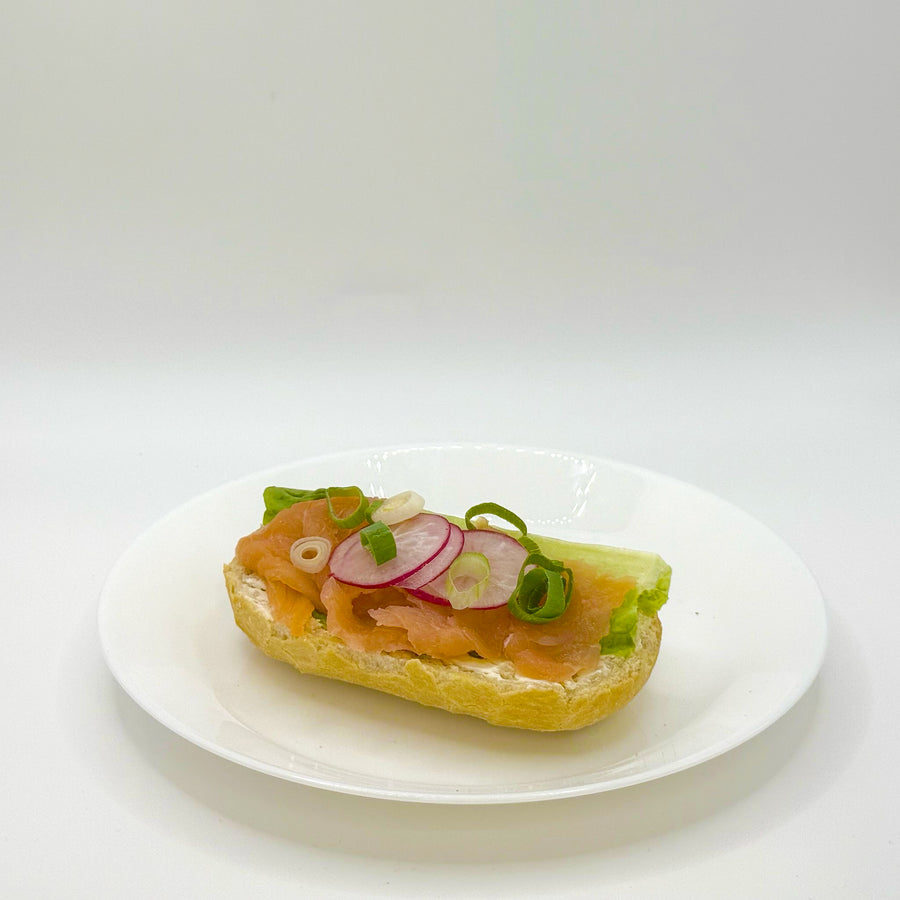 halbes belegtes Weizenbrötchen mit geräuchertem Lachs